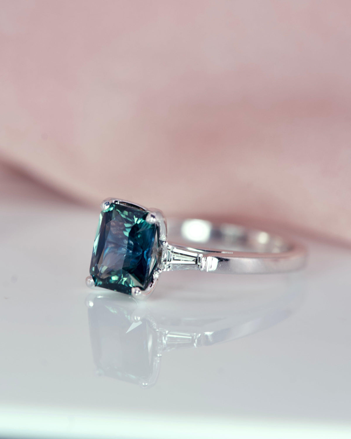 Close-up teal sapphire and baguette diamond ring