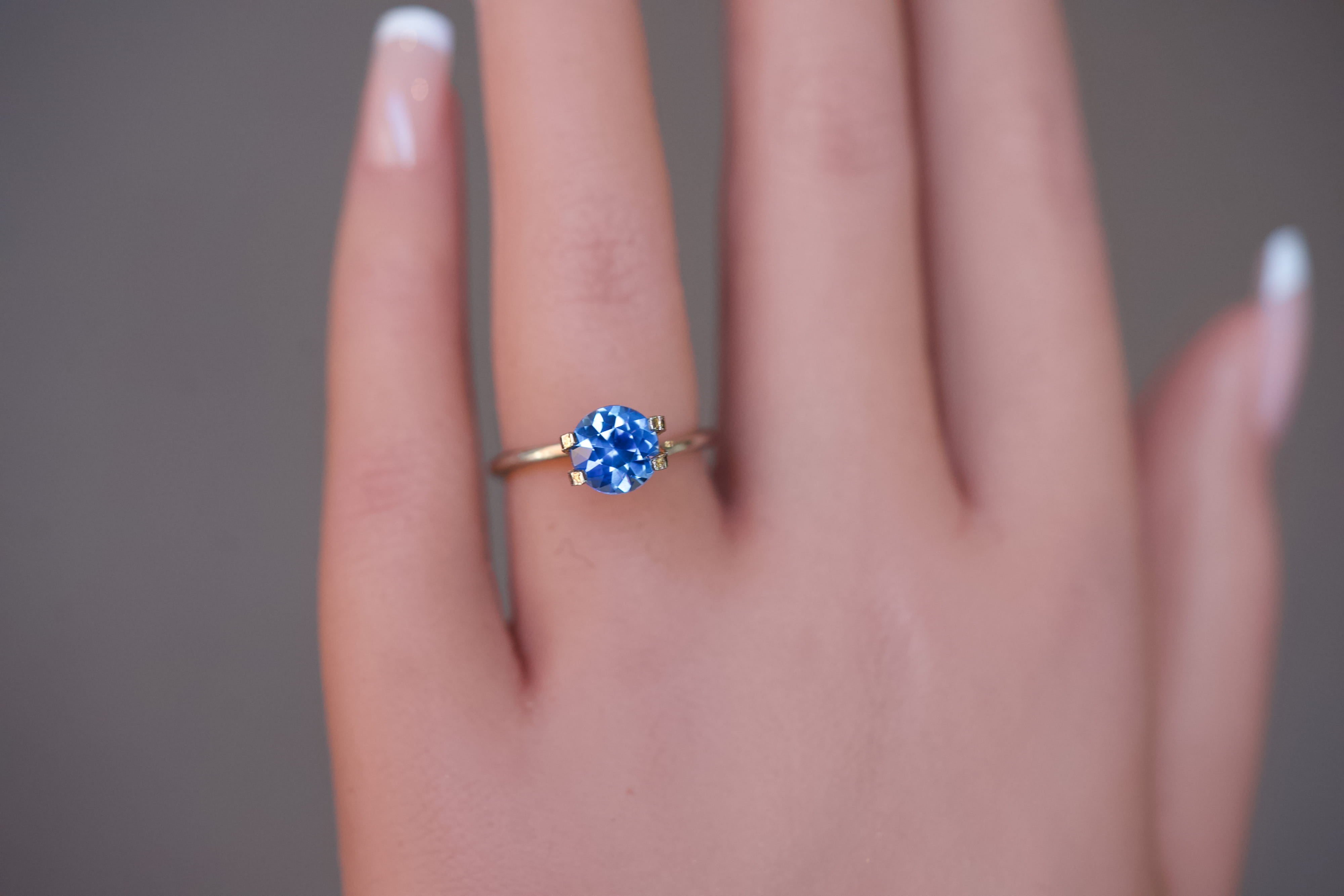 Heated blue Ceylon round sapphire worn in a temporary ring setting.