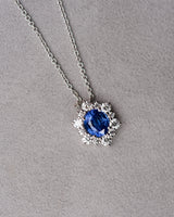 Blue sapphire pendant with diamond halo, flat lay