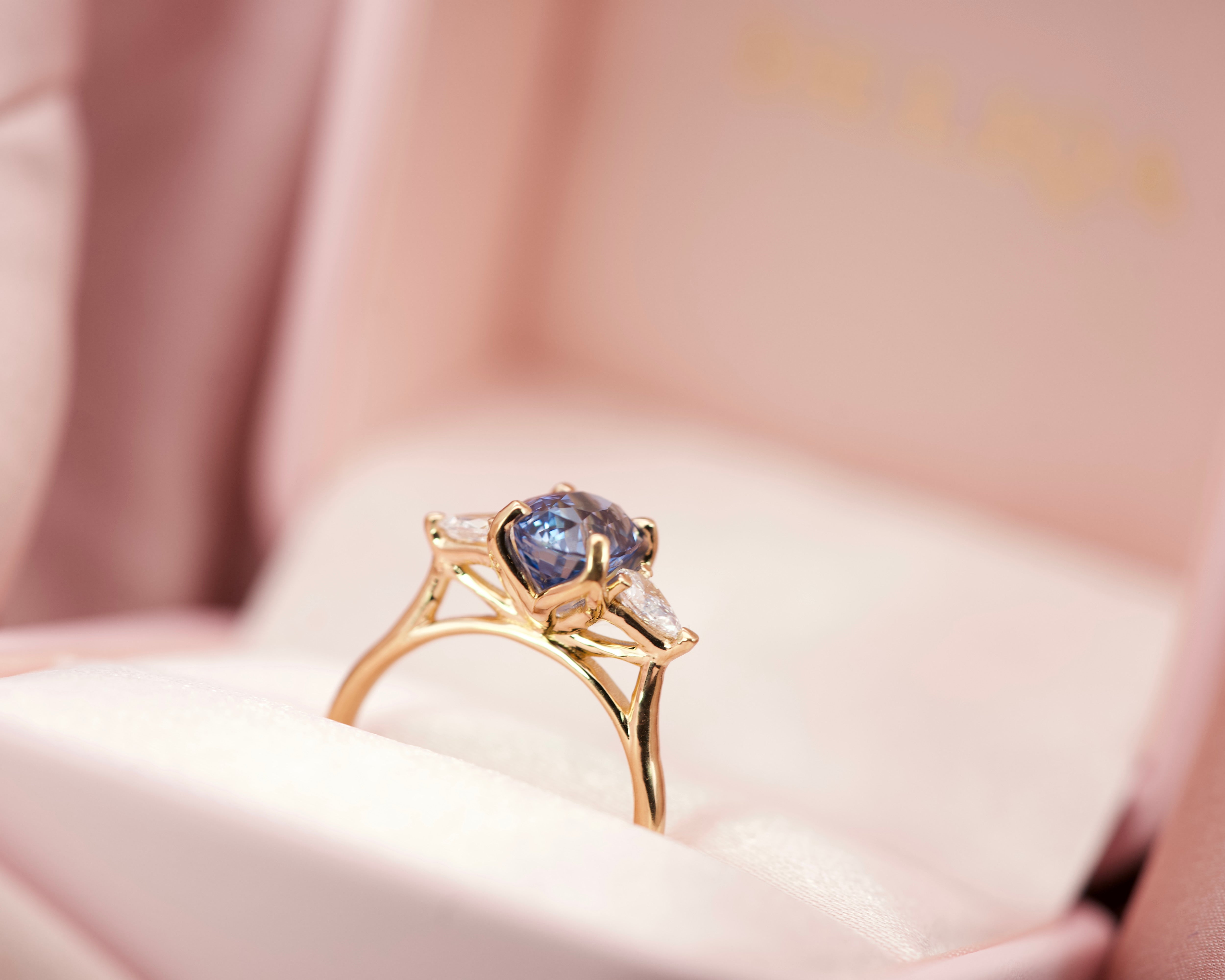 Luxury blue sapphire trilogy engagement ring presented in a signature pink velvet jewellery box