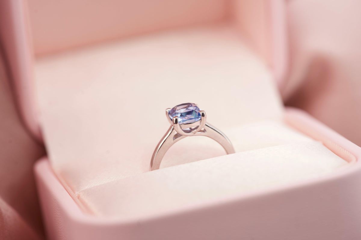 Luxury cornflower blue sapphire solitaire ring in a signature pink velvet box
