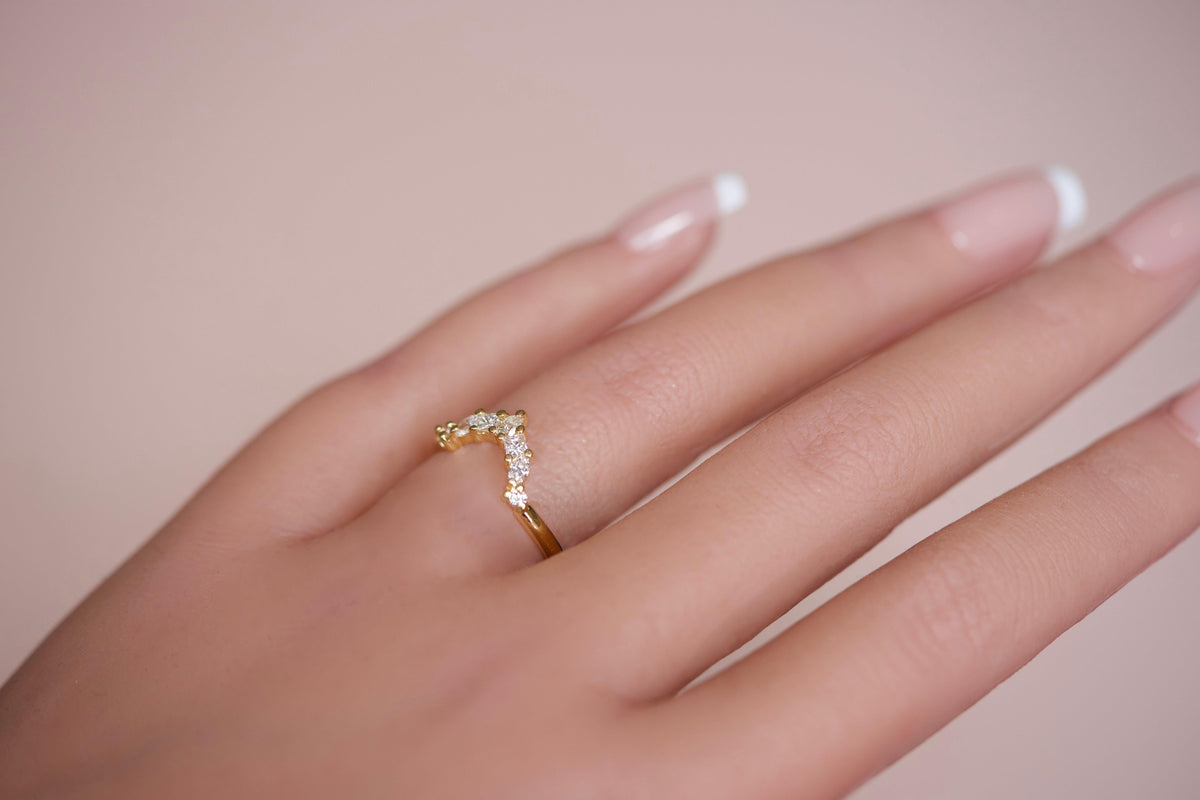 Diamond crown wedding band worn on hand, close-up