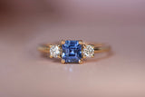 Handcrafted Ceylon sapphire and diamond trilogy ring in 18k yellow gold with low profile setting, front view on neutral background