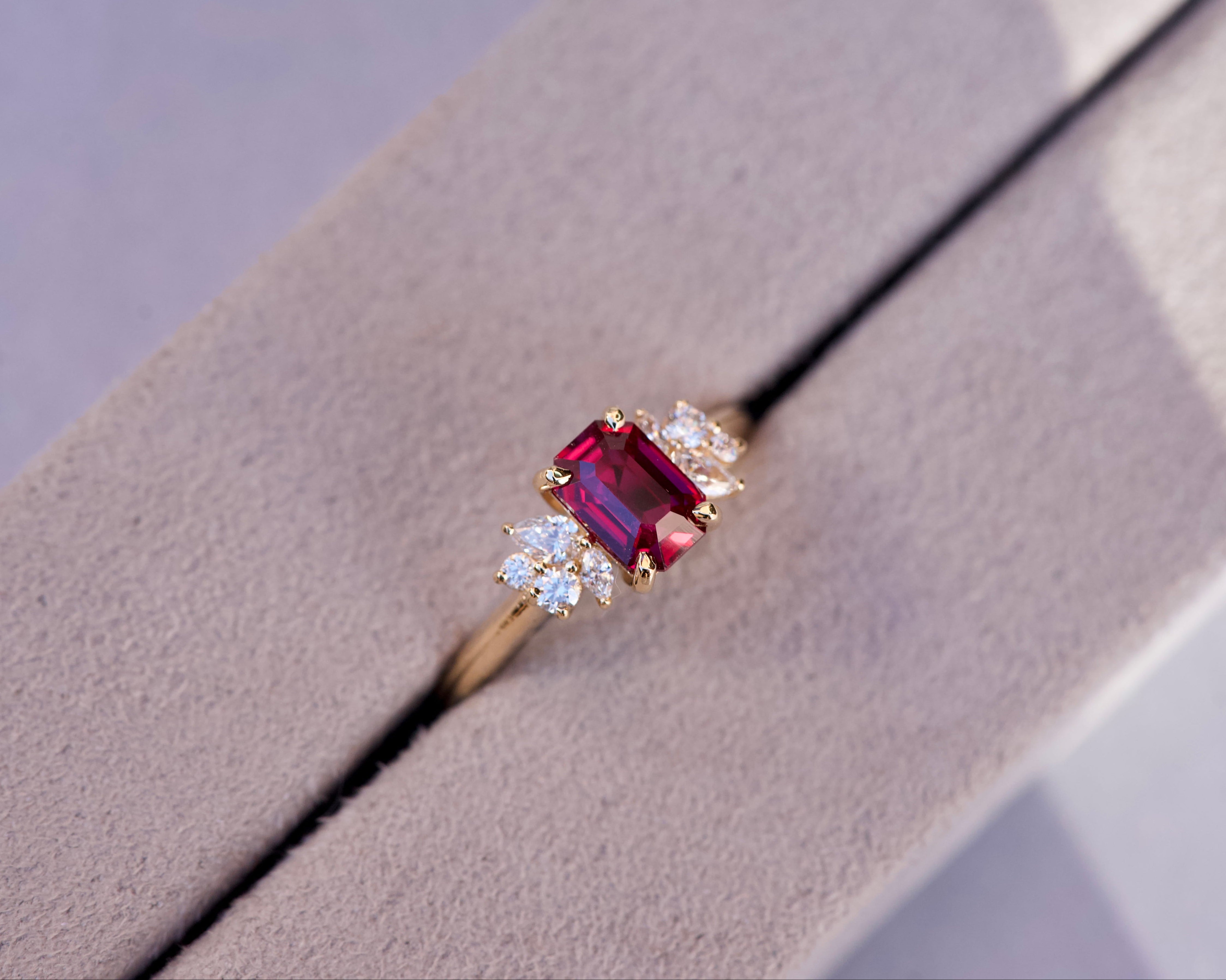 Overhead wide view of a step cut ruby cluster ring nestled inside a grey luxury box