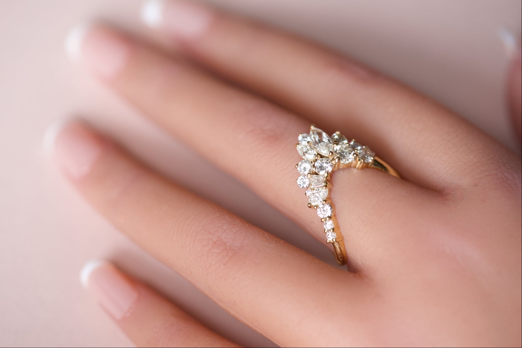 Handcrafted diamond cluster curved wedding band worn on hand demonstrating the nesting fit