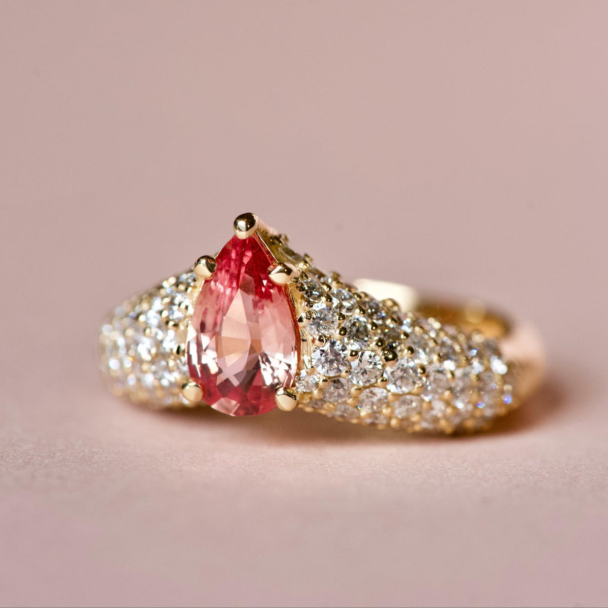Pinkish orange sapphire ring with diamonds, angle