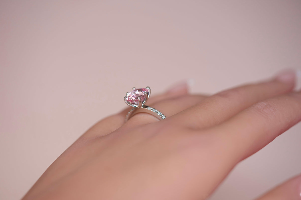 Pink sapphire diamond halo ring worn on hand