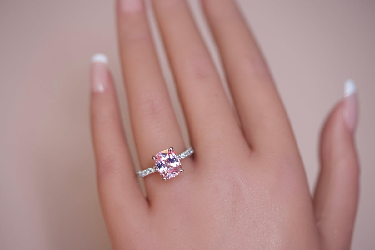 Cushion cut pink sapphire ring on hand, close-up
