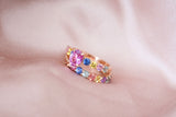 Pink sapphire engagement ring stacked with rainbow band