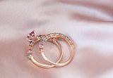 Pink sapphire engagement ring stacked with rainbow band