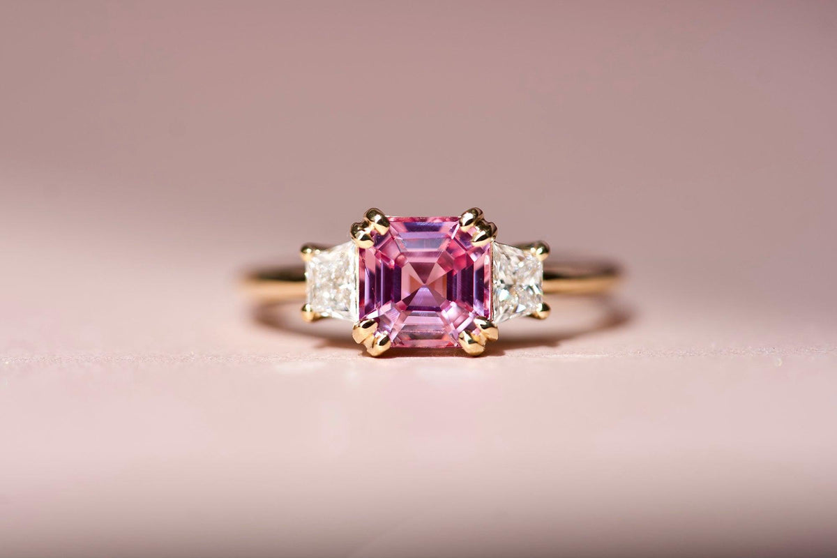 Emerald cut pink sapphire with diamond side stones