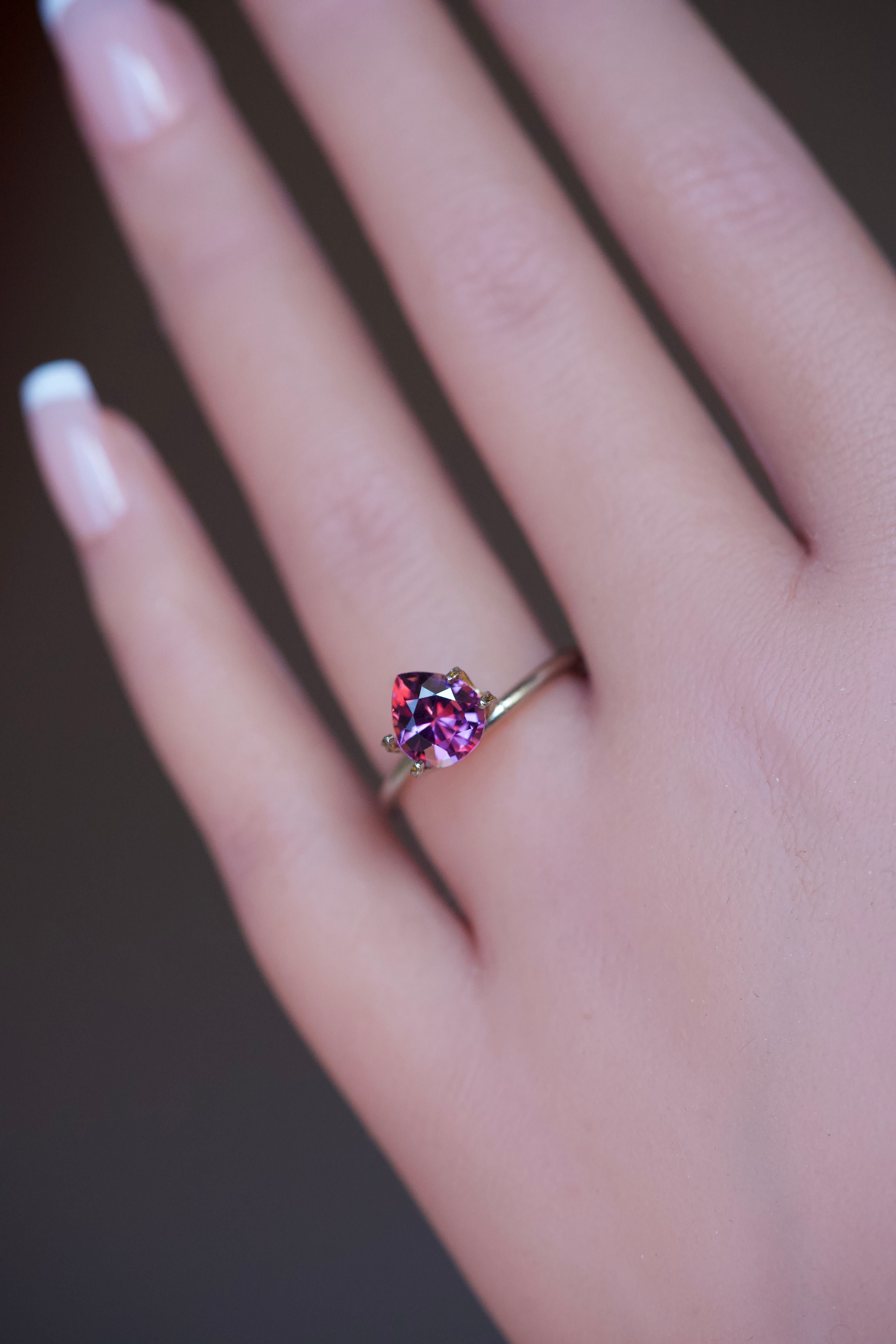 Teardrop shaped magenta garnet jewel styled in a delicate gold band.