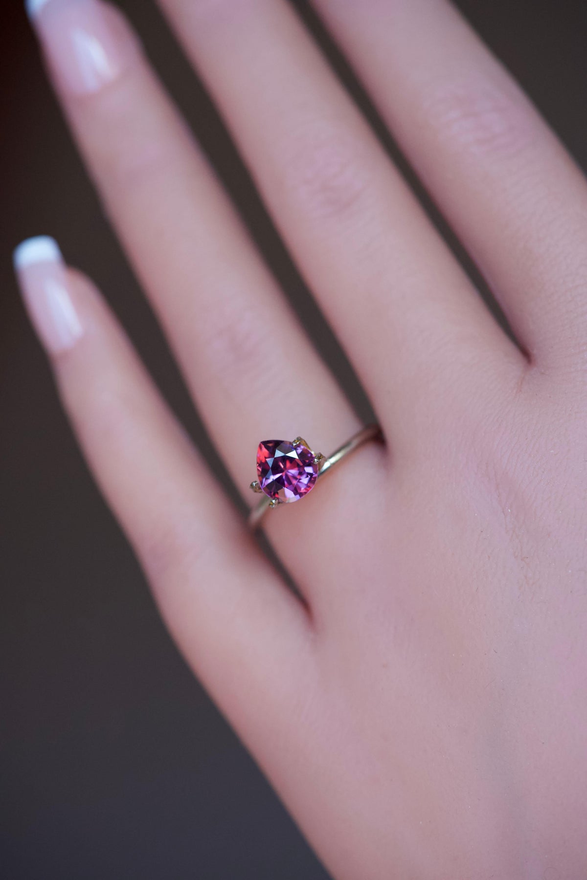 Teardrop shaped magenta garnet jewel styled in a delicate gold band.