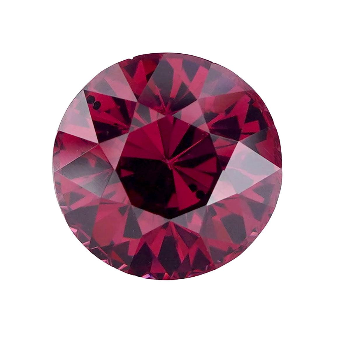 Studio macro shot of a round cut purplish pink garnet.