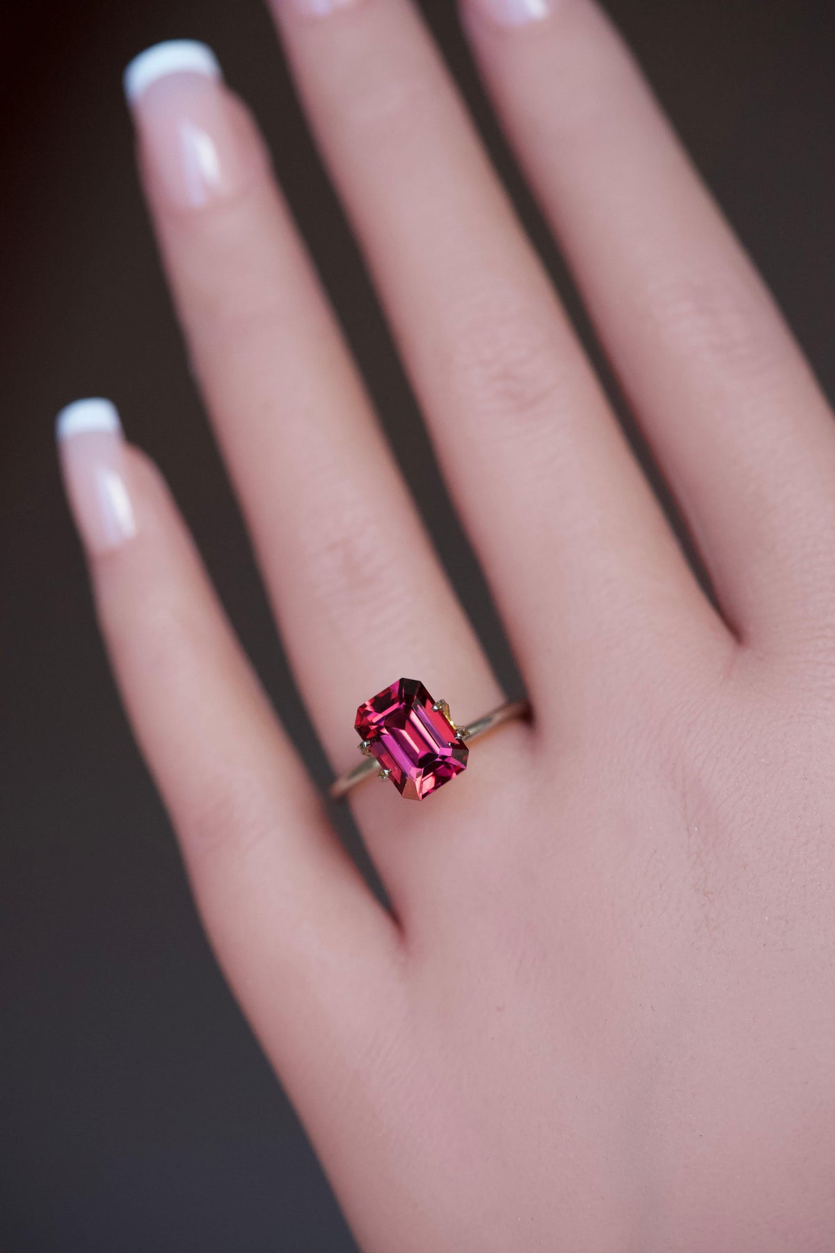 A model wearing a vibrant purplish pink garnet mockup ring.