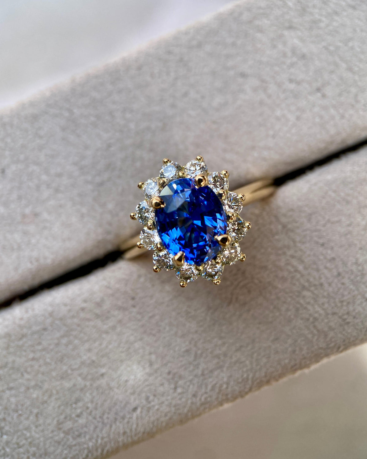 Vivid cornflower blue sapphire starburst ring resting inside a plush grey velvet jewellery box