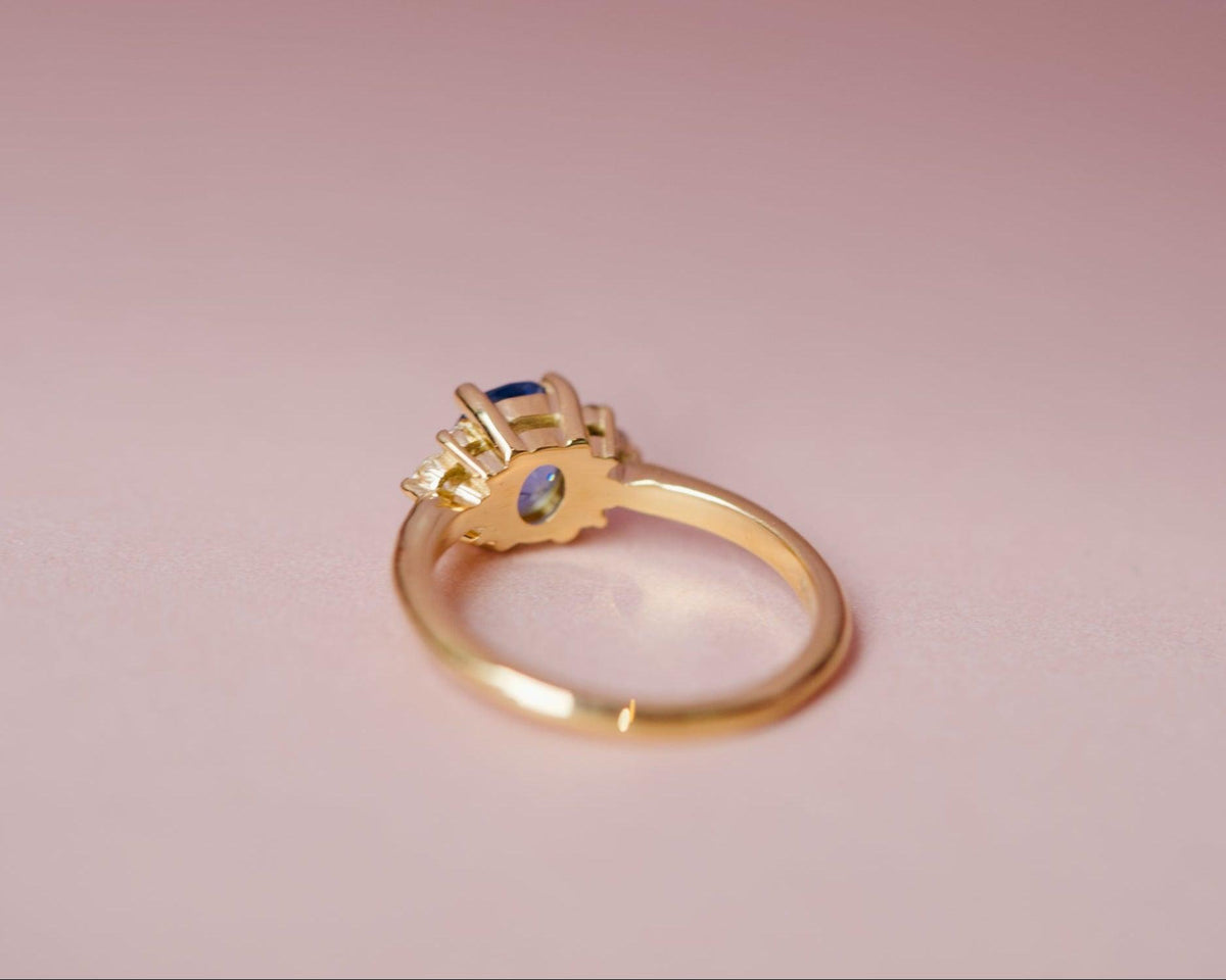 Underside view of the gold basket and setting for an oval sapphire and diamond cluster ring