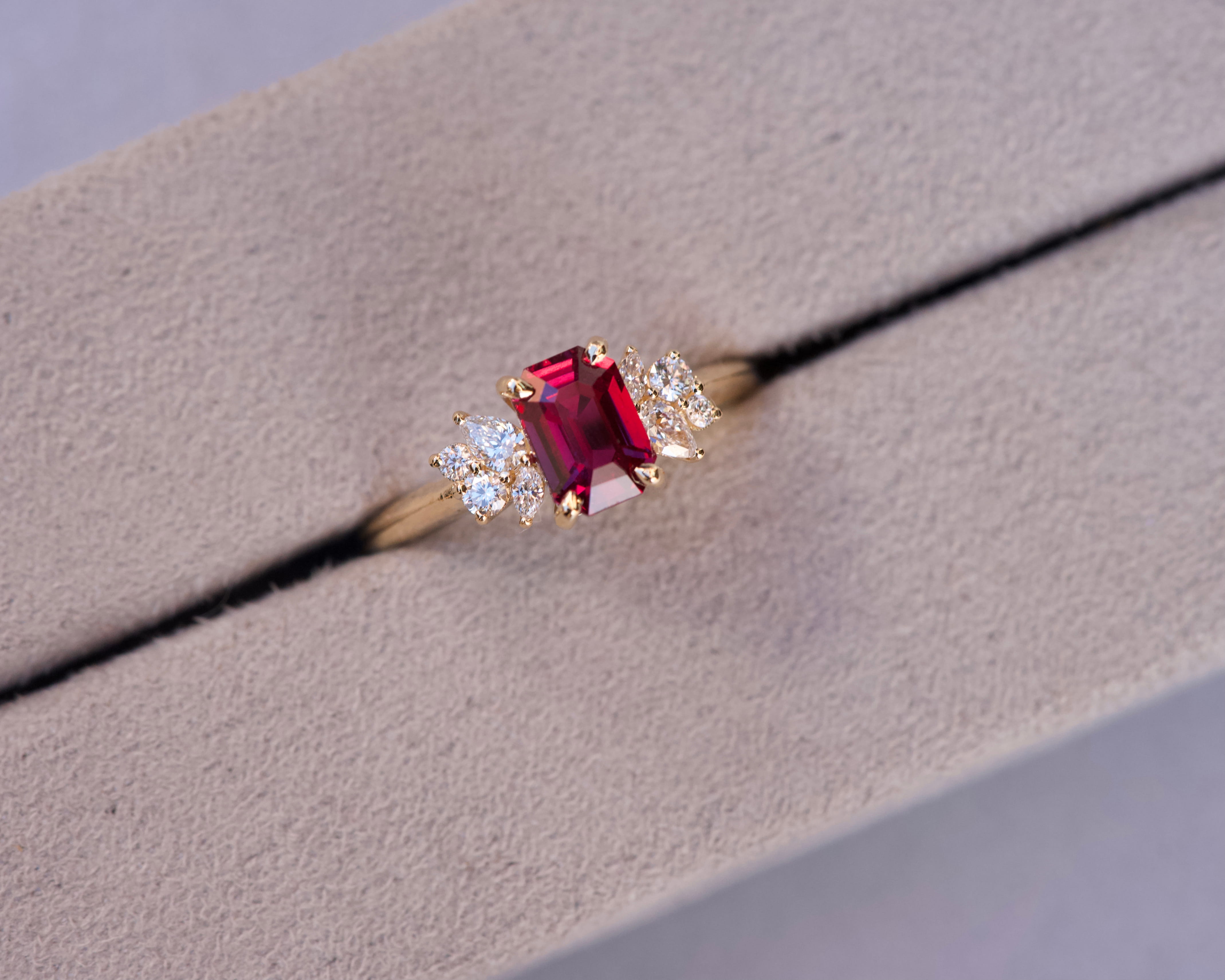 Unheated emerald cut Mozambique ruby ring with diamond clusters in a grey velvet box