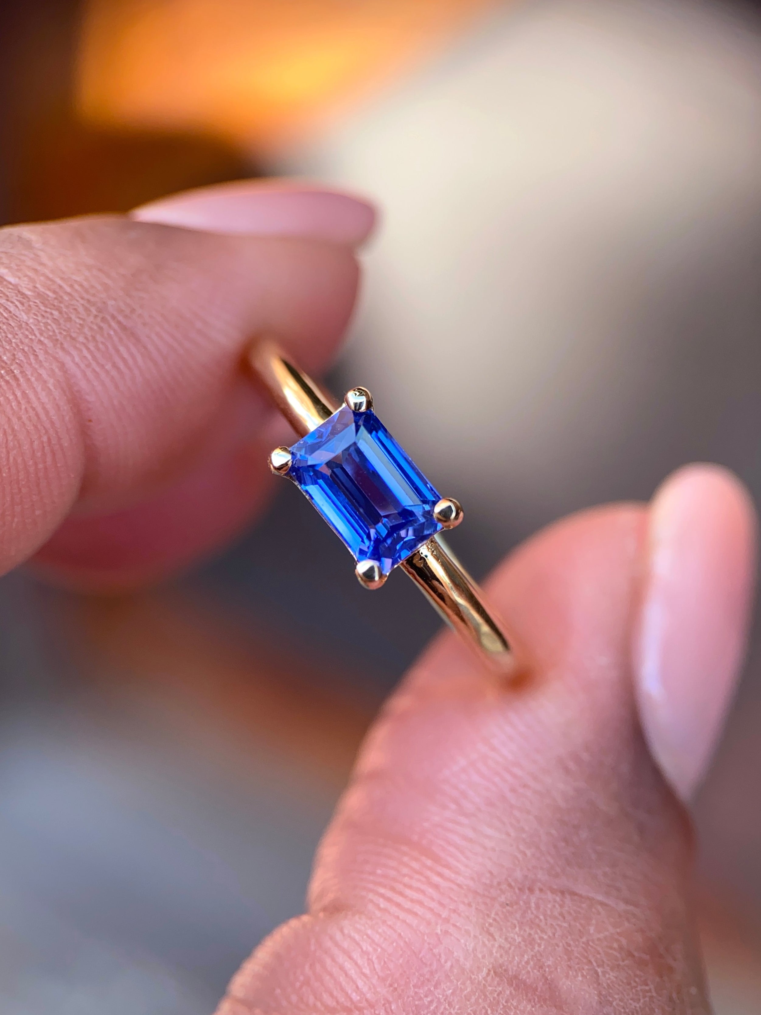 Handheld shot of a 1.09 ct unheated blue sapphire ring reflecting vibrant cornflower tones in natural light