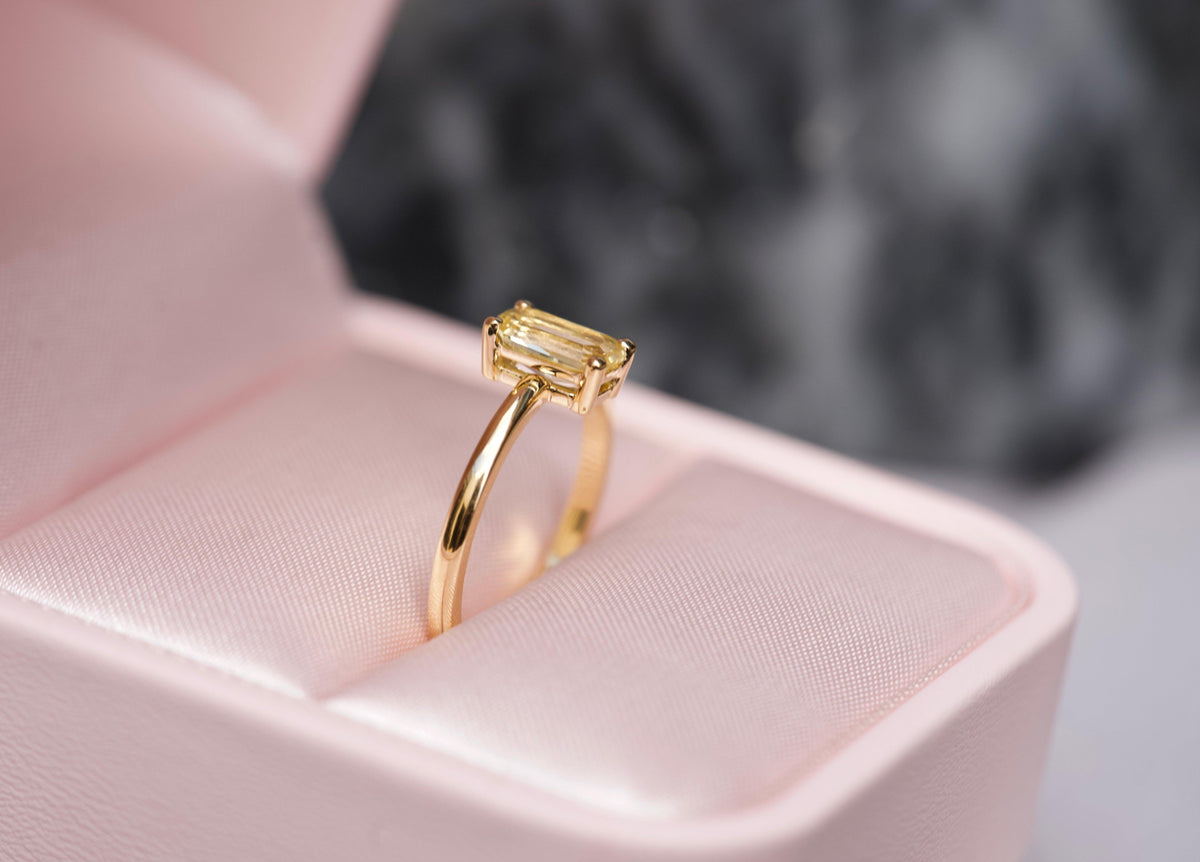 Yellow sapphire emerald cut ring in box, side view