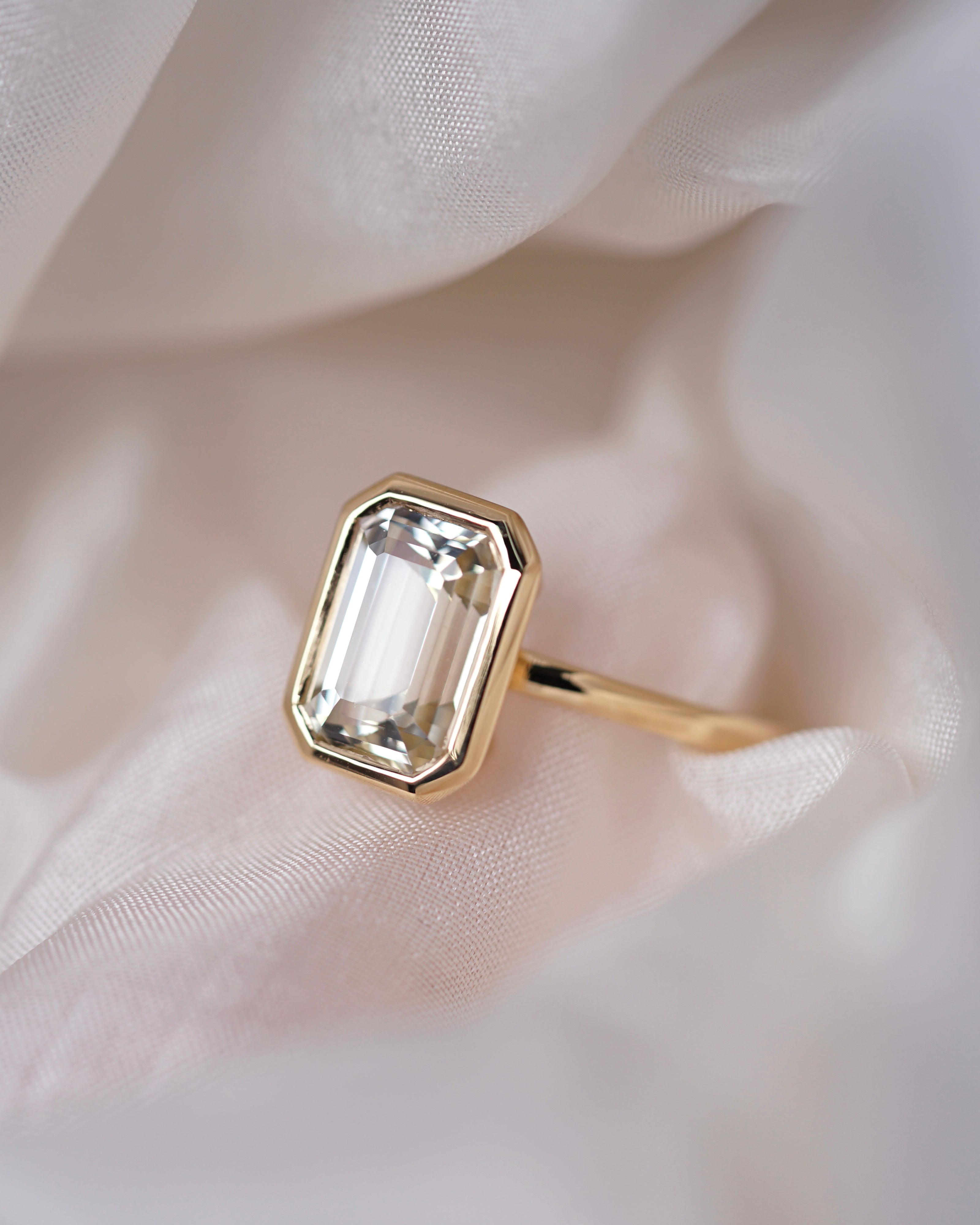 Emerald cut champagne sapphire bezel ring in yellow gold