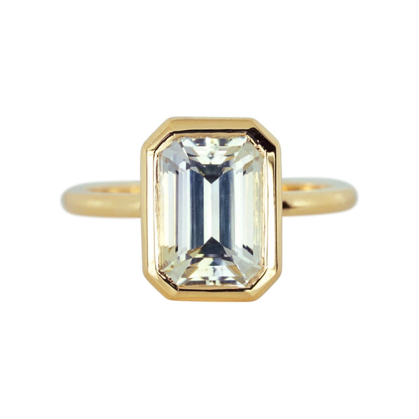 Emerald cut champagne sapphire bezel ring in yellow gold