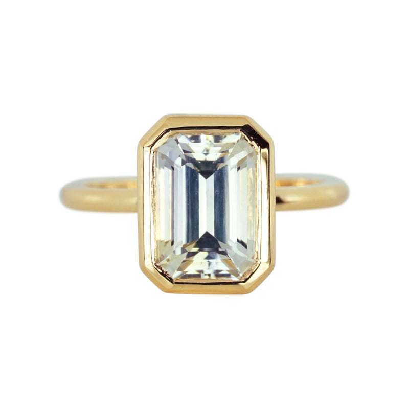 Emerald cut champagne sapphire bezel ring in yellow gold