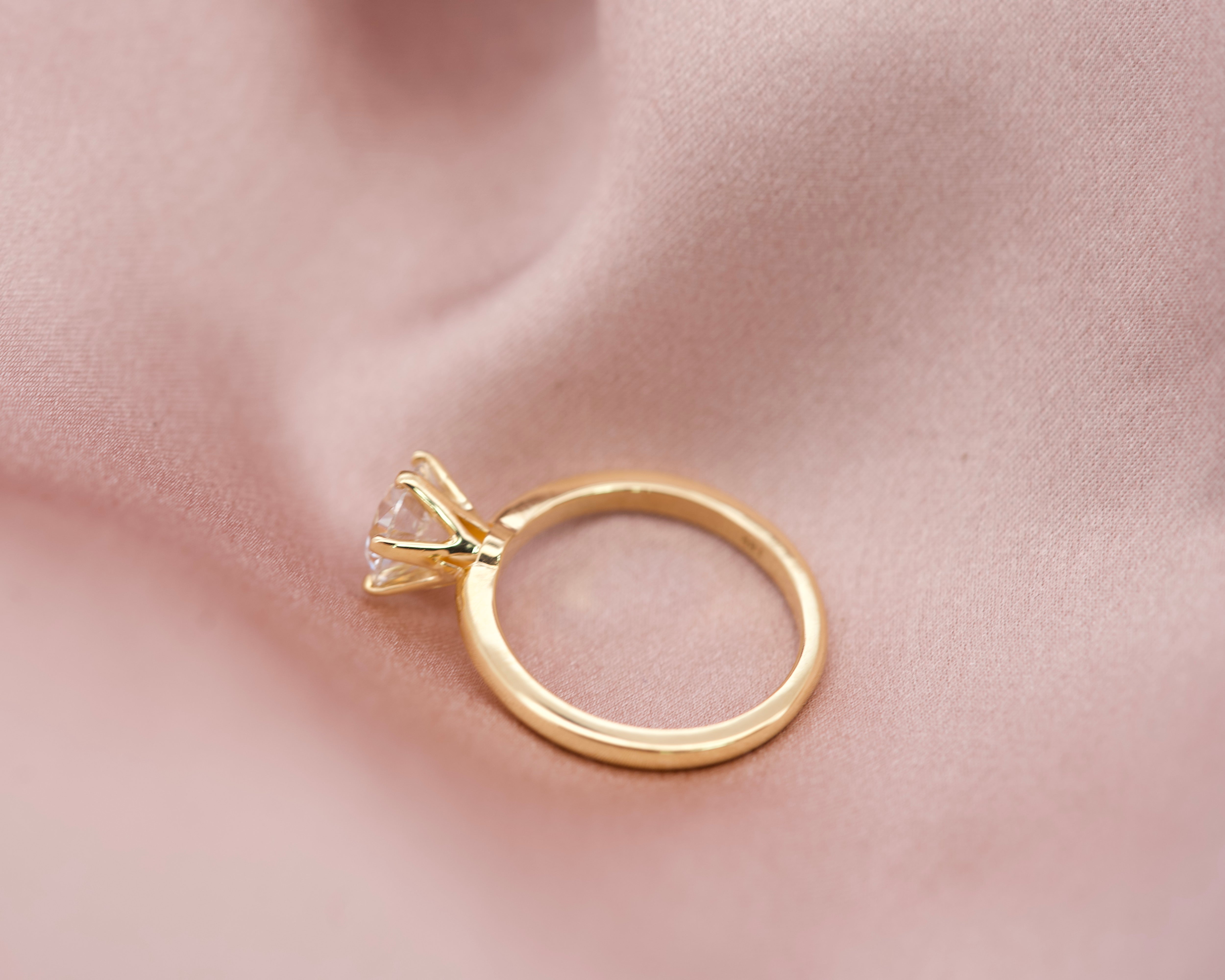 Side profile of a classic yellow gold diamond engagement ring showing the six-prong crown