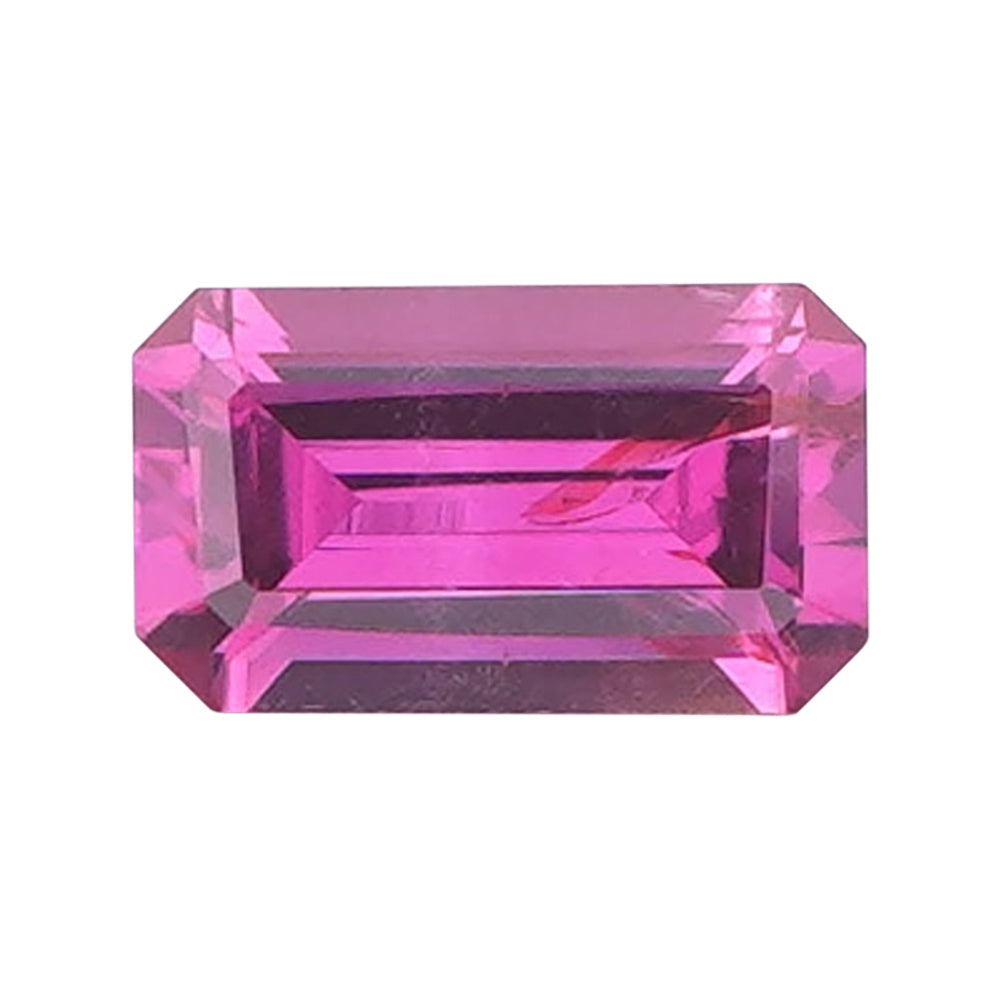 Vivid magenta rectangular step-cut loose gemstone on a clean white background.