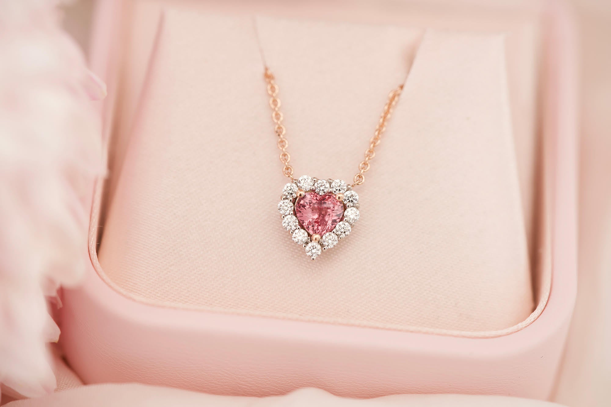 Padparadscha sapphire and diamond heart necklace in a pink box.