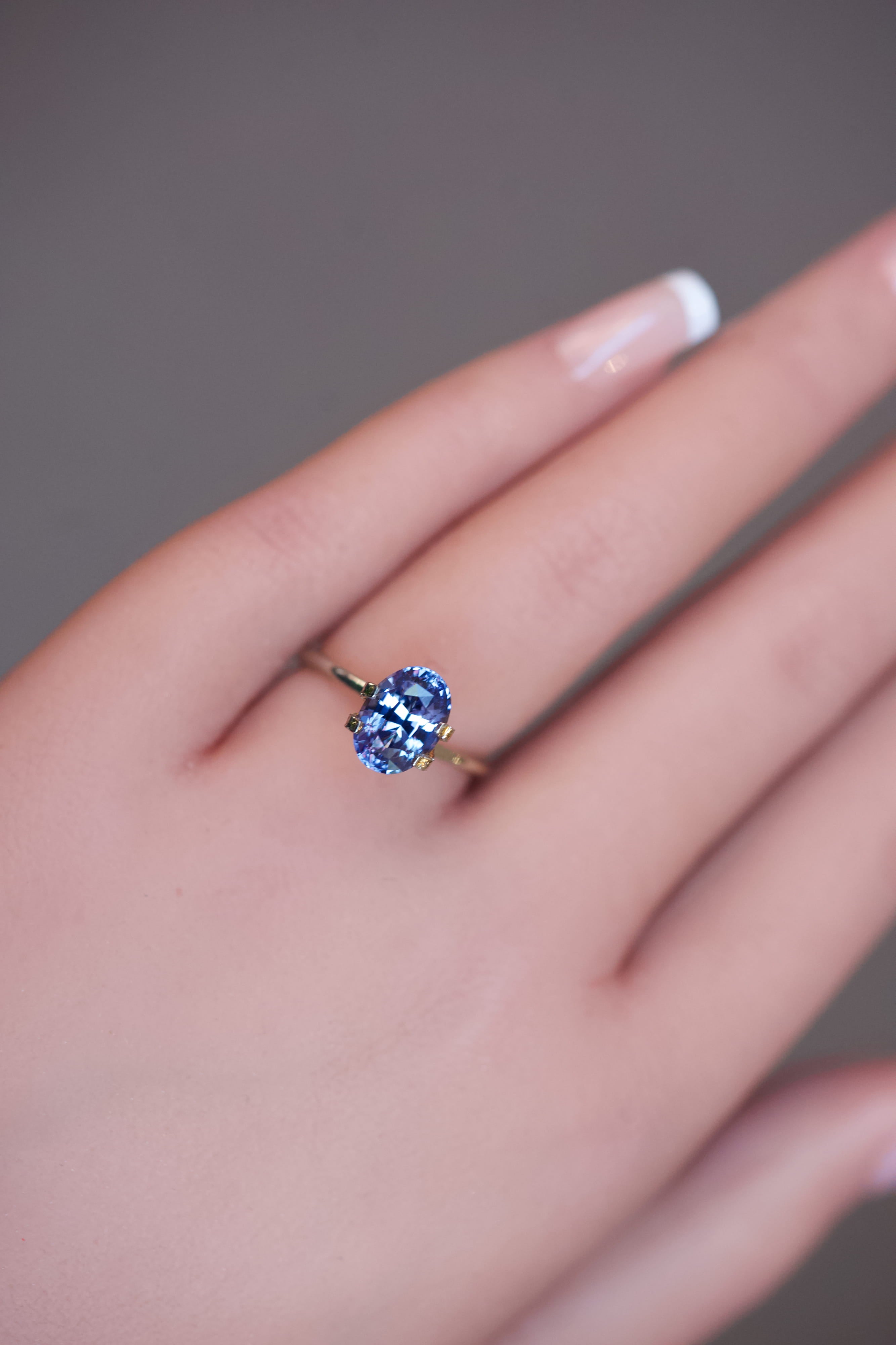 Close-up of a color-shifting bluish-violet oval sapphire resting in a mock-up ring setting.