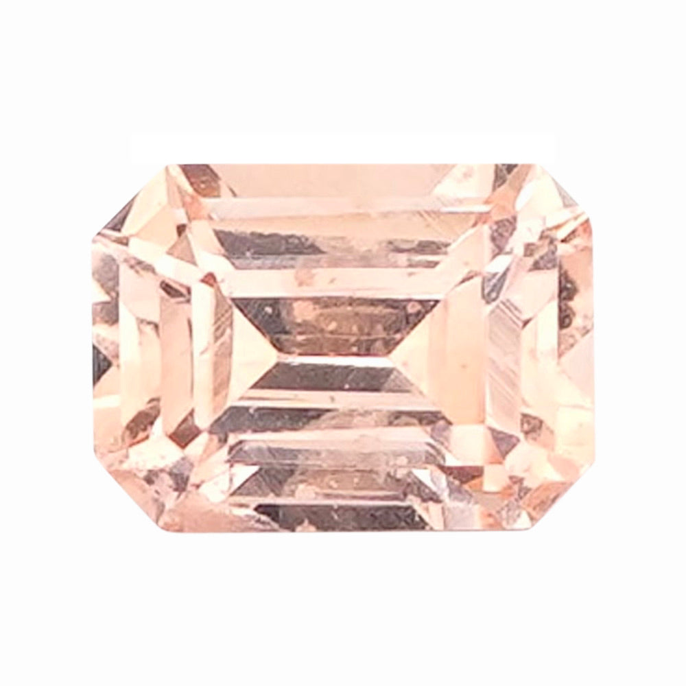 Rectangular step-cut loose sapphire in a soft pinkish orange.