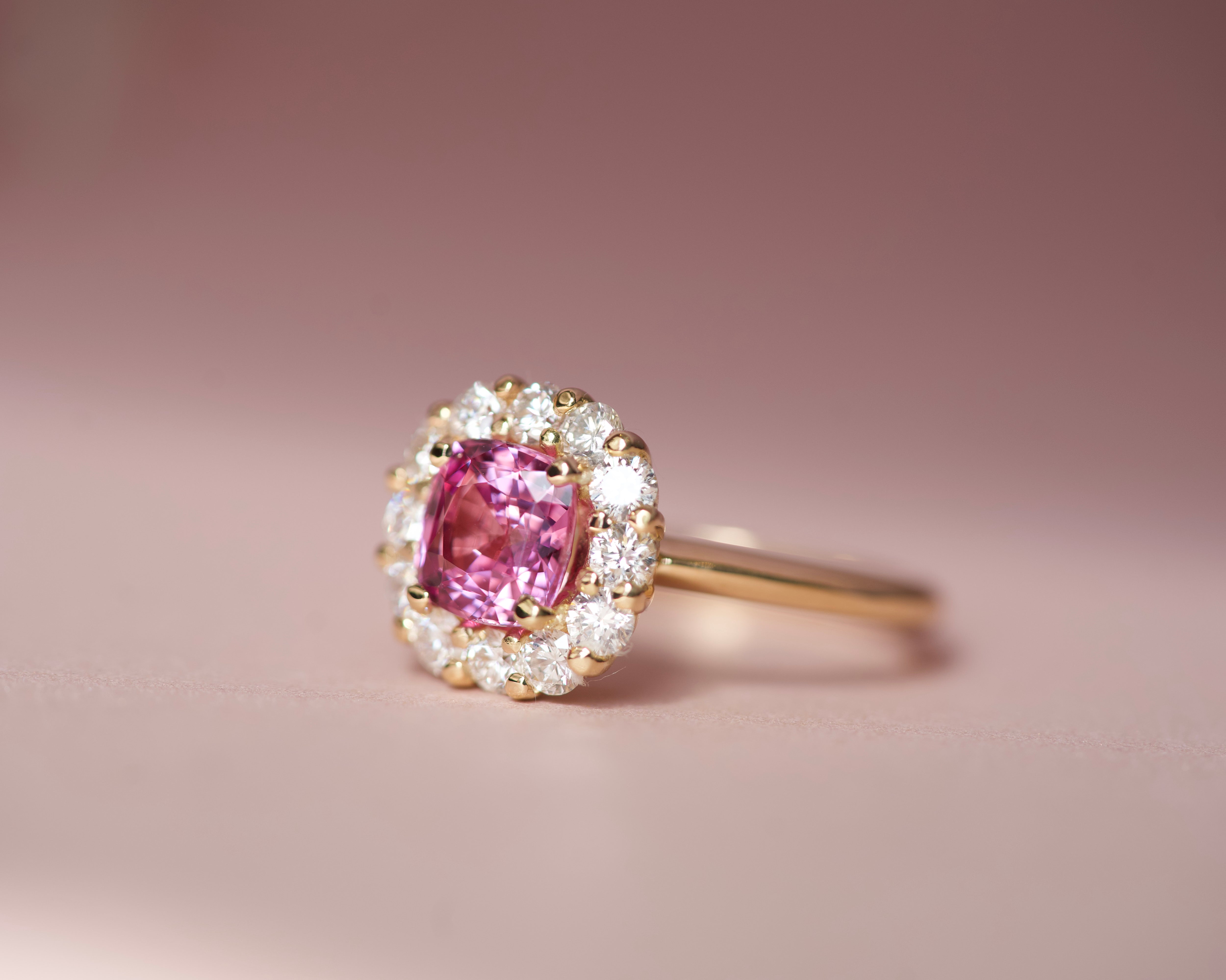 Pink sapphire halo engagement ring in yellow gold