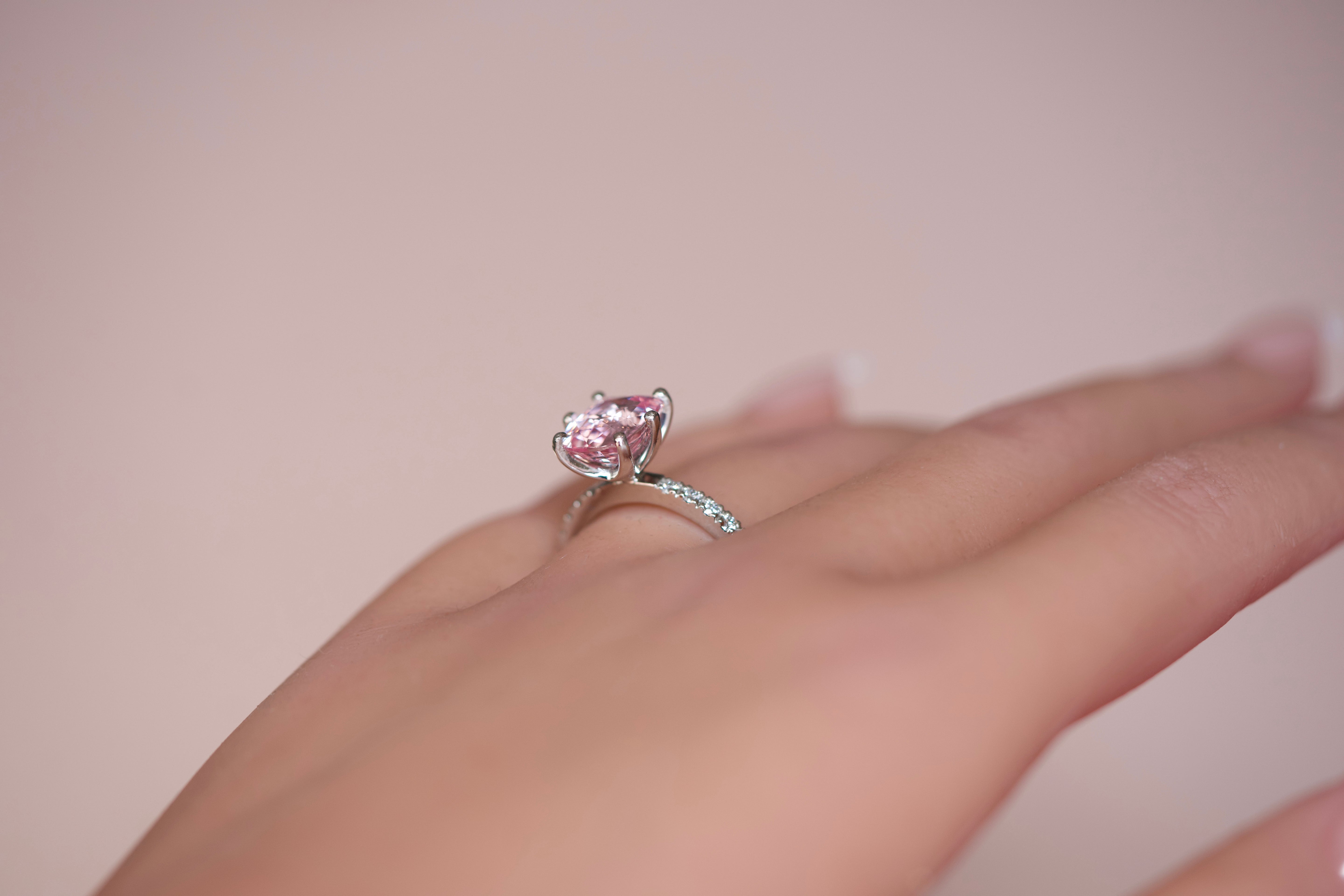 Pink sapphire diamond halo ring worn on hand