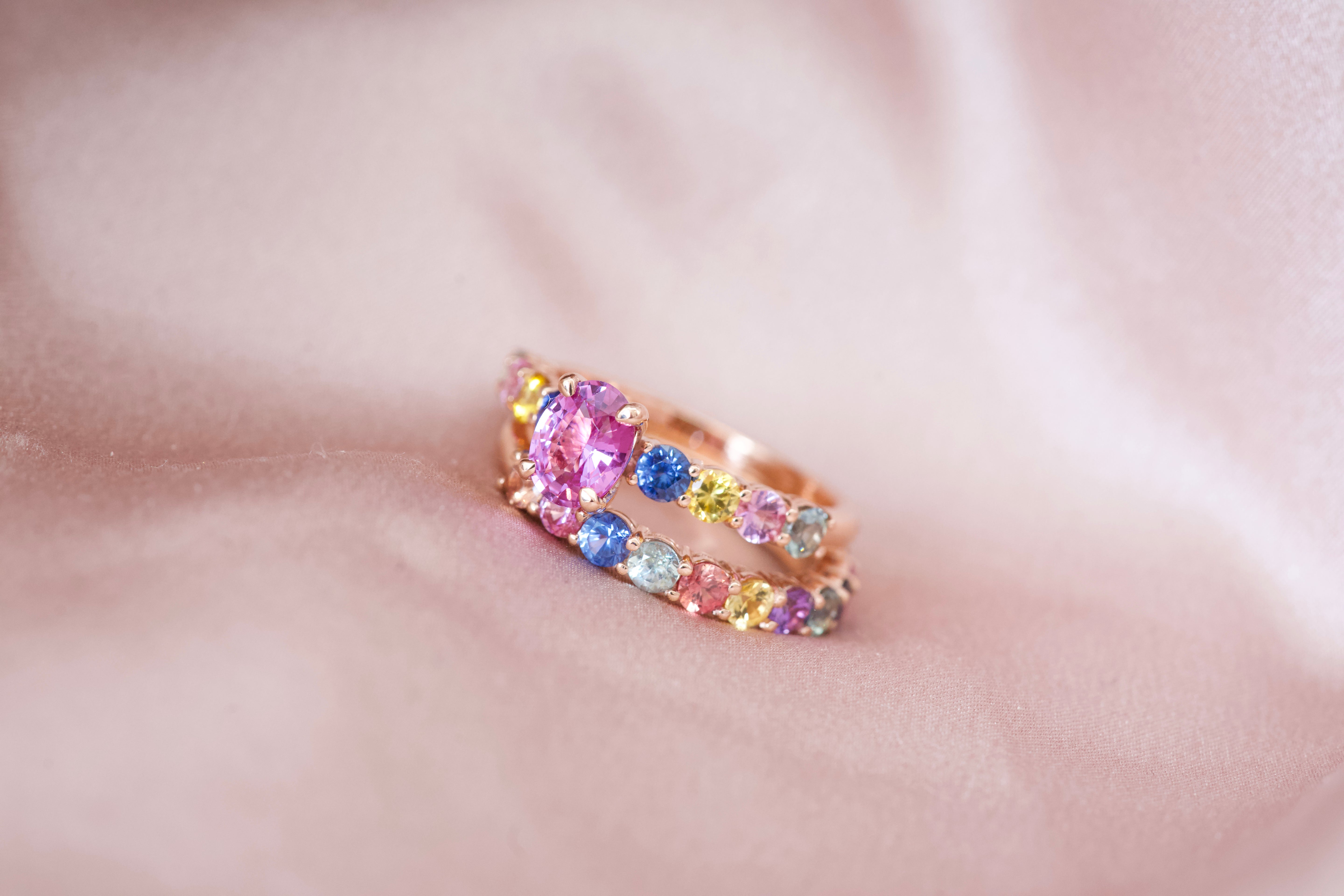 Pink sapphire engagement ring stacked with rainbow band
