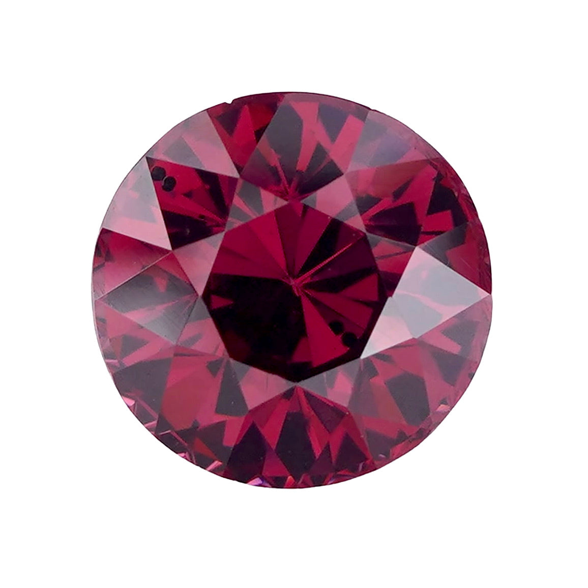 Studio macro shot of a round cut purplish pink garnet.