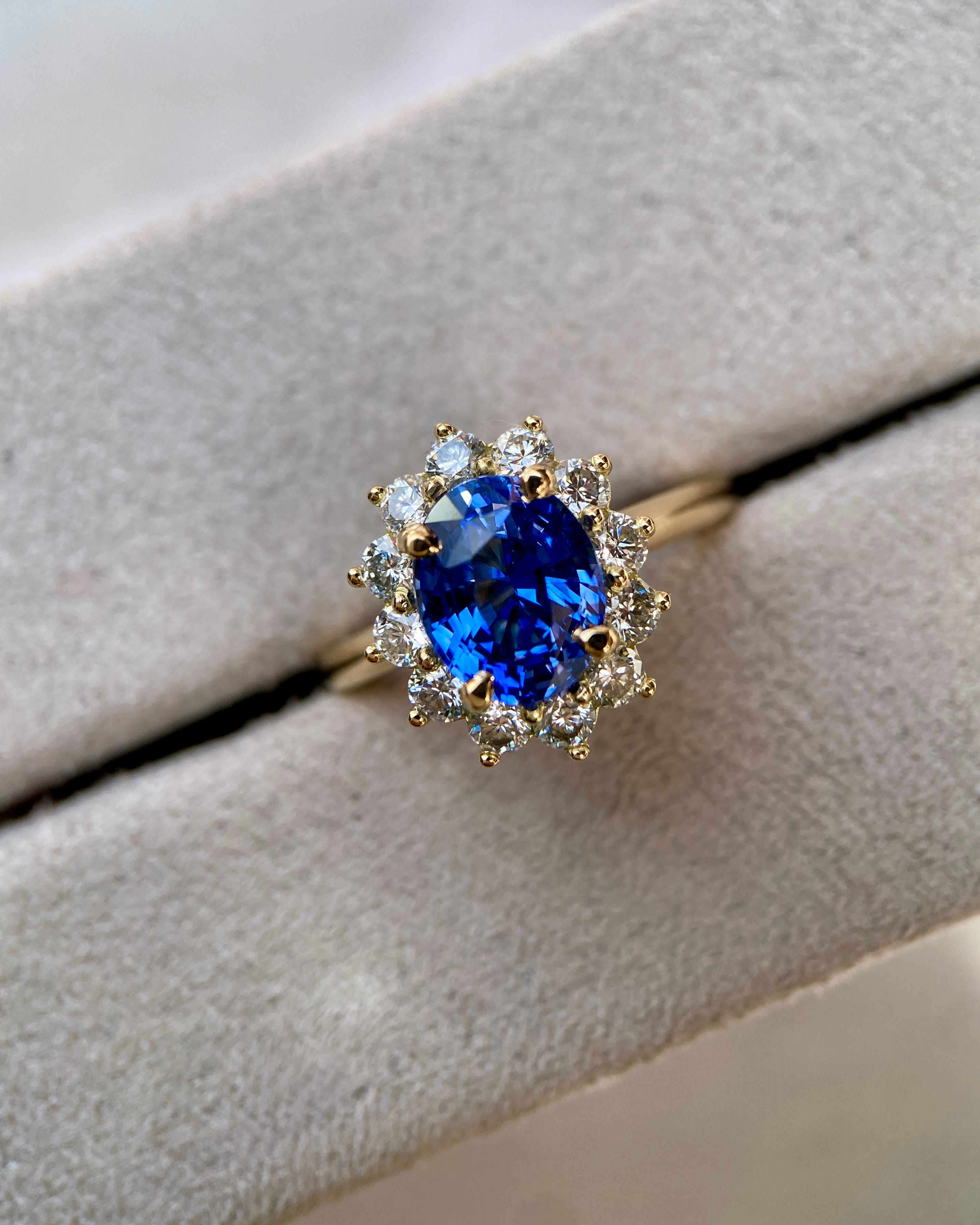 Vivid cornflower blue sapphire starburst ring resting inside a plush grey velvet jewellery box
