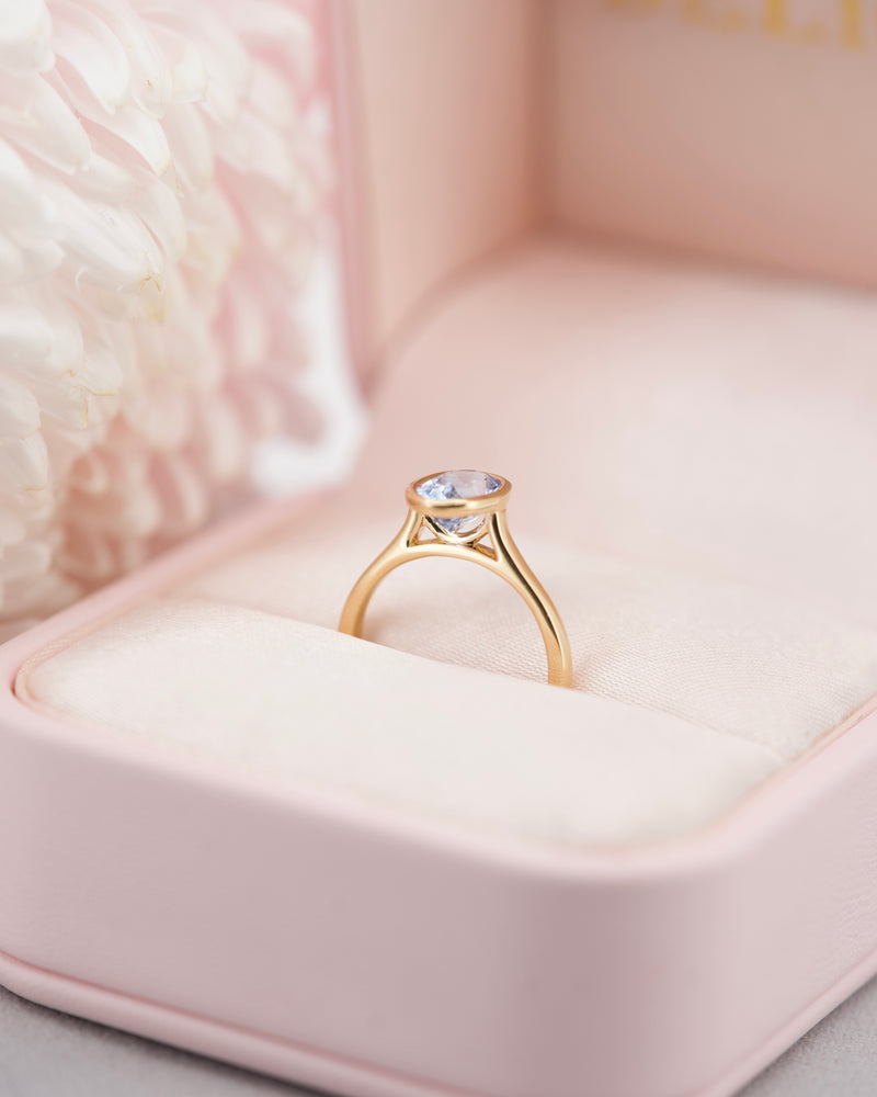 Oval sapphire bezel ring in yellow gold, side profile view