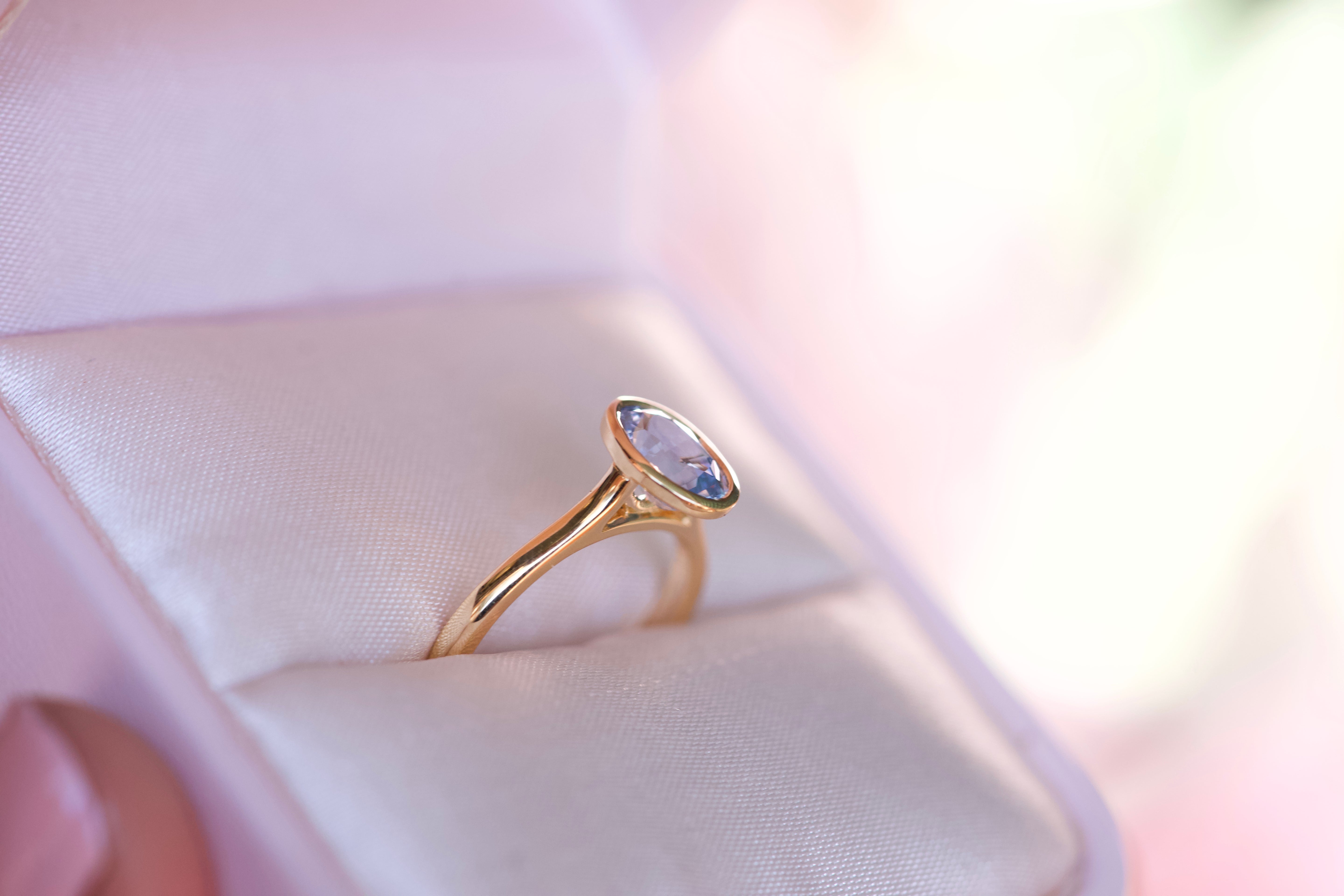 Sky blue oval Ceylon sapphire in yellow gold bezel setting