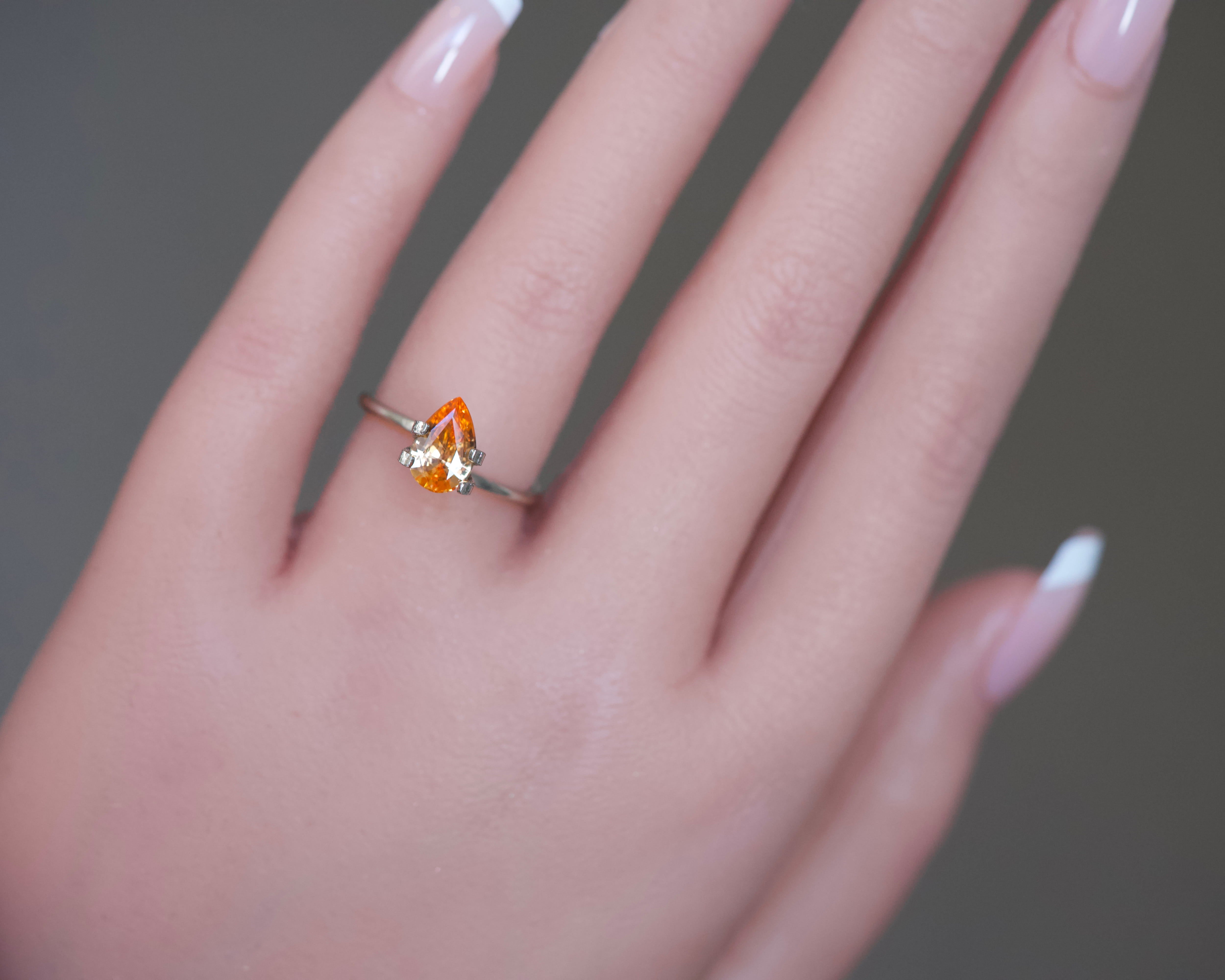 A fiery yellowish-orange pear-cut sapphire from Ceylon styled in a mockup ring prong setting