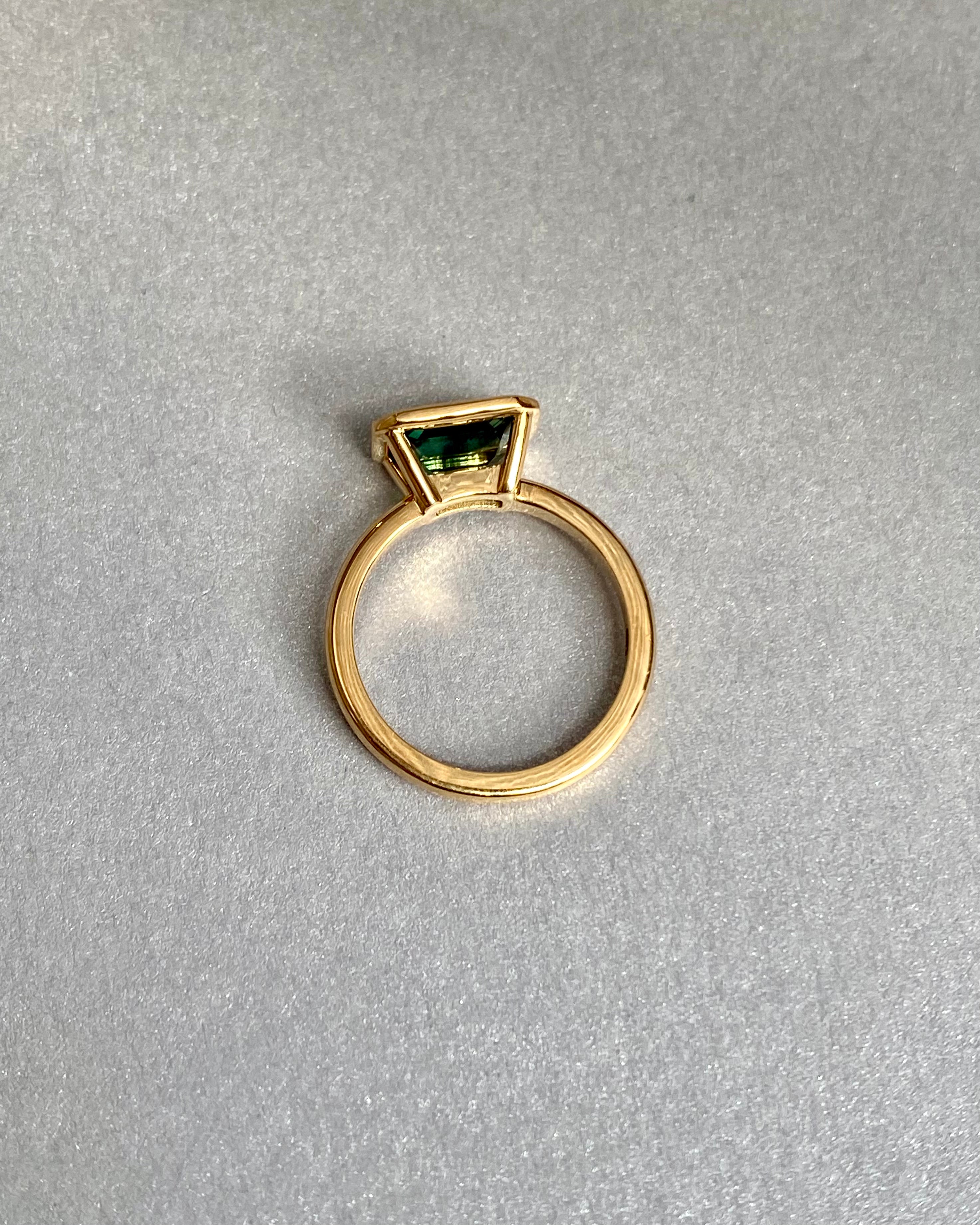 Bluish green sapphire bezel ring, flat lay view