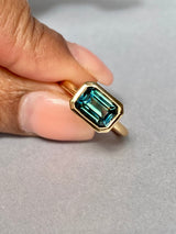 Green sapphire east-west ring worn on hand, close-up