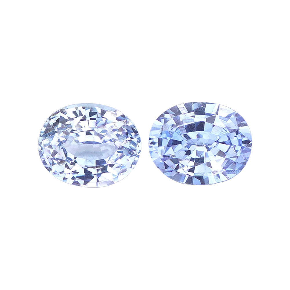Pair of very light violet-blue oval mixed-cut loose stones on white.