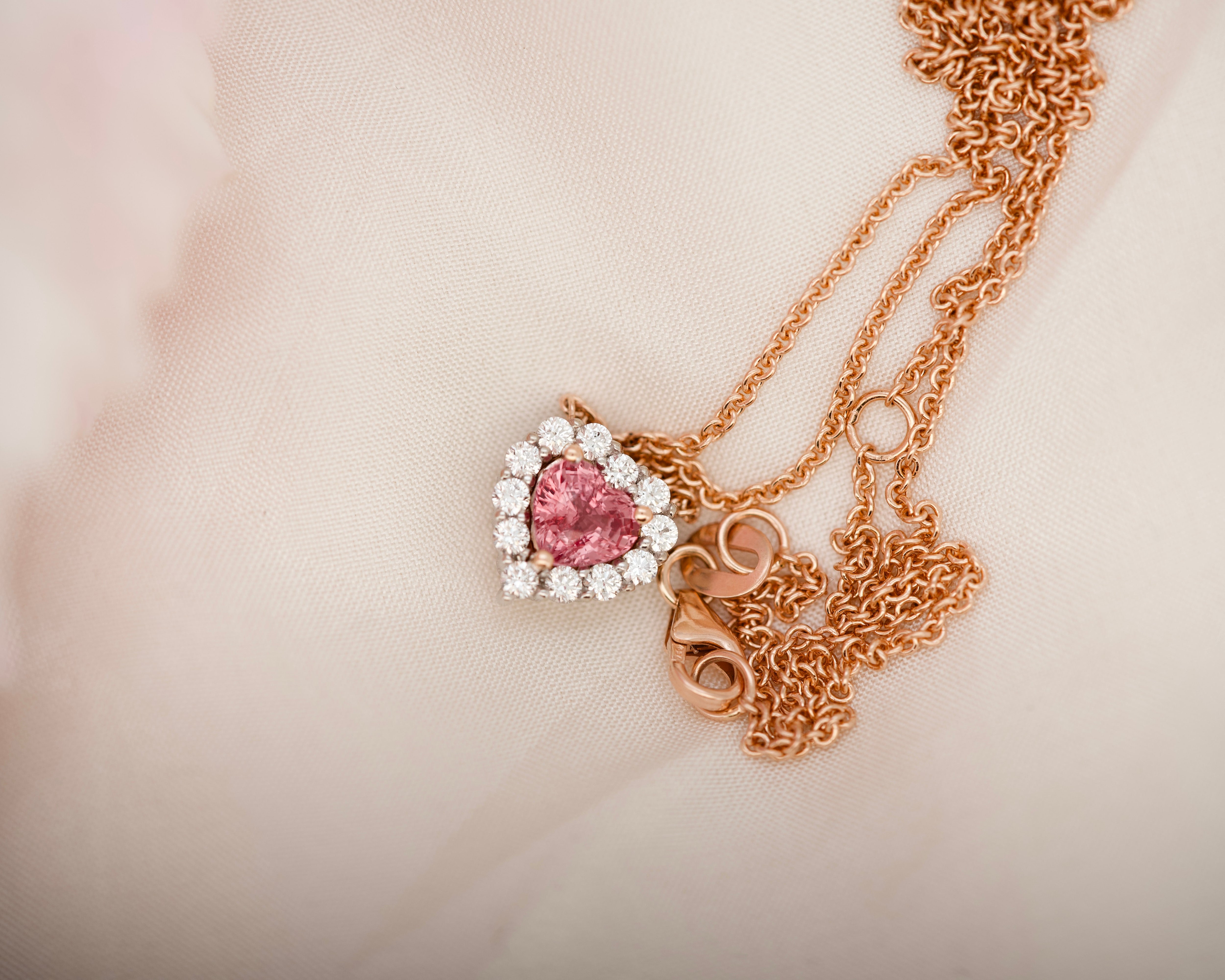 Padparadscha sapphire heart pendant with a rose gold chain and clasp.